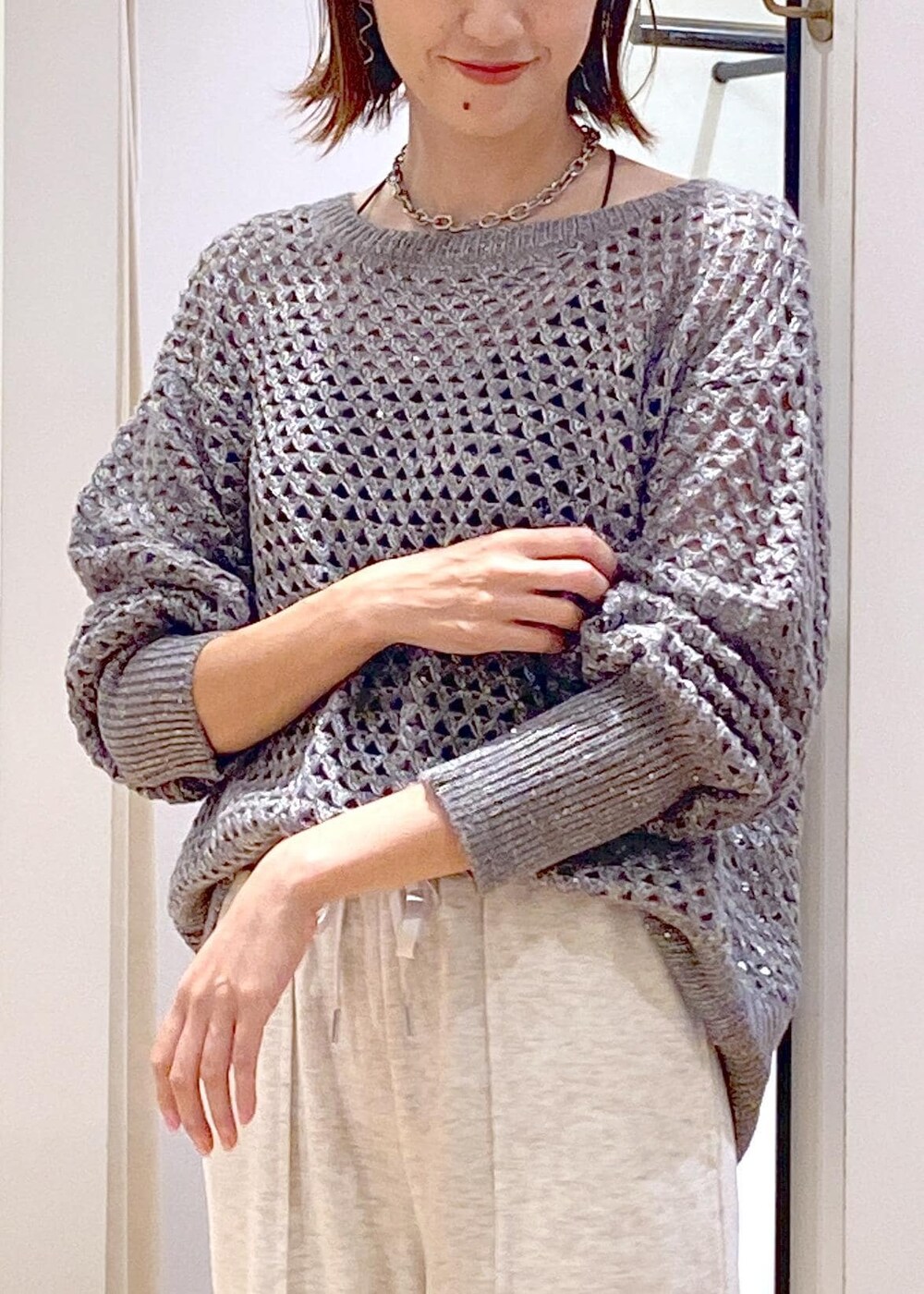 ホワイト系のその他パンツ、グレー系のニット/セーター、ブラック系のハンドバッグを着用したレディースの秋コーディネートの5枚目の写真