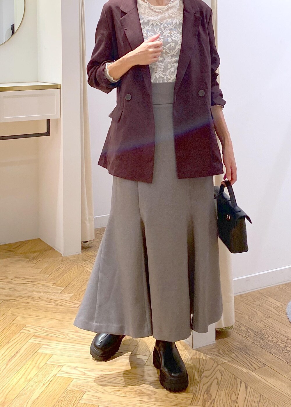 ブラック系のキャミソール、その他のショルダーバッグ、ブラック系のブーツを着用したレディースの秋コーディネートの4枚目の写真