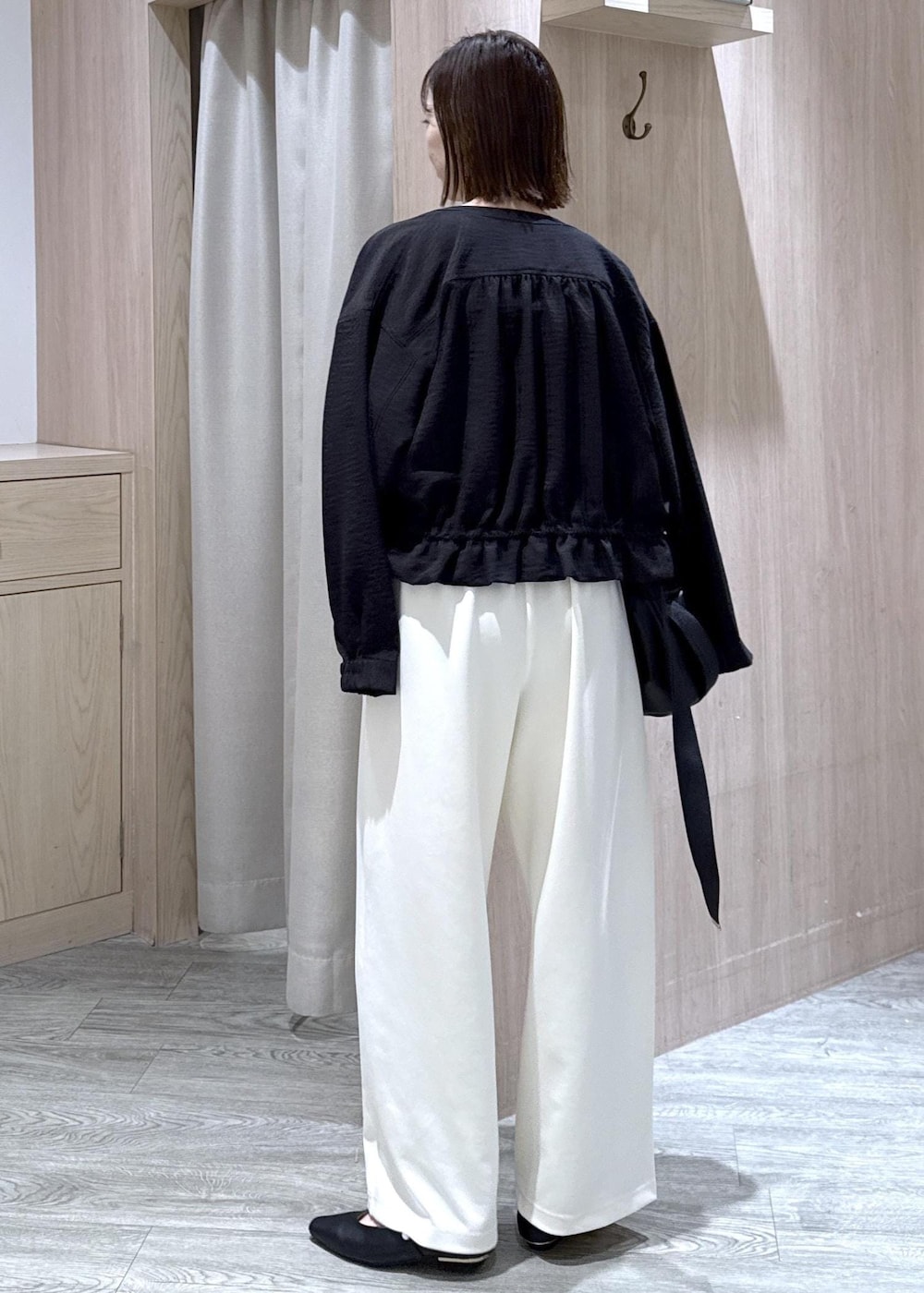 ブラック系のパンプス、ブラック系のトートバッグ、ブラック系のブルゾンを着用したレディースの春コーディネートの2枚目の写真