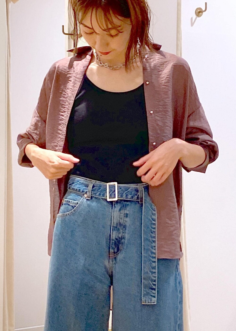 ブラック系のキャミソール、ホワイト系のショルダーバッグ、ブルー系のデニムパンツを着用したレディースの秋コーディネートの9枚目の写真