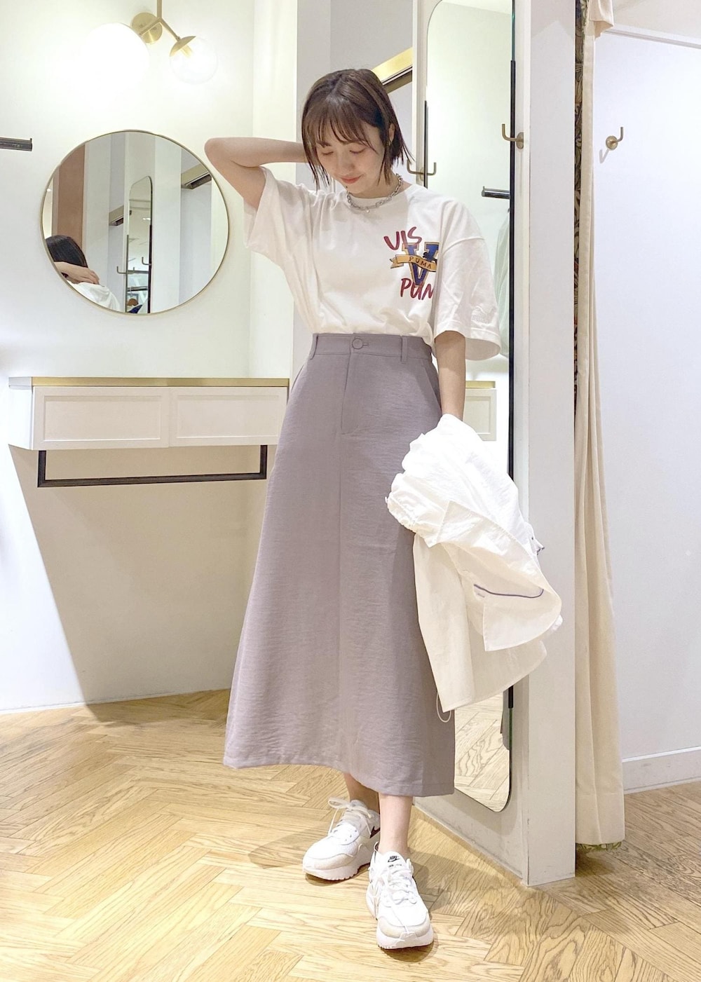 グレー系のスカート、ホワイト系のブルゾン、ホワイト系のTシャツ/カットソーを着用したレディースの春コーディネートの5枚目の写真