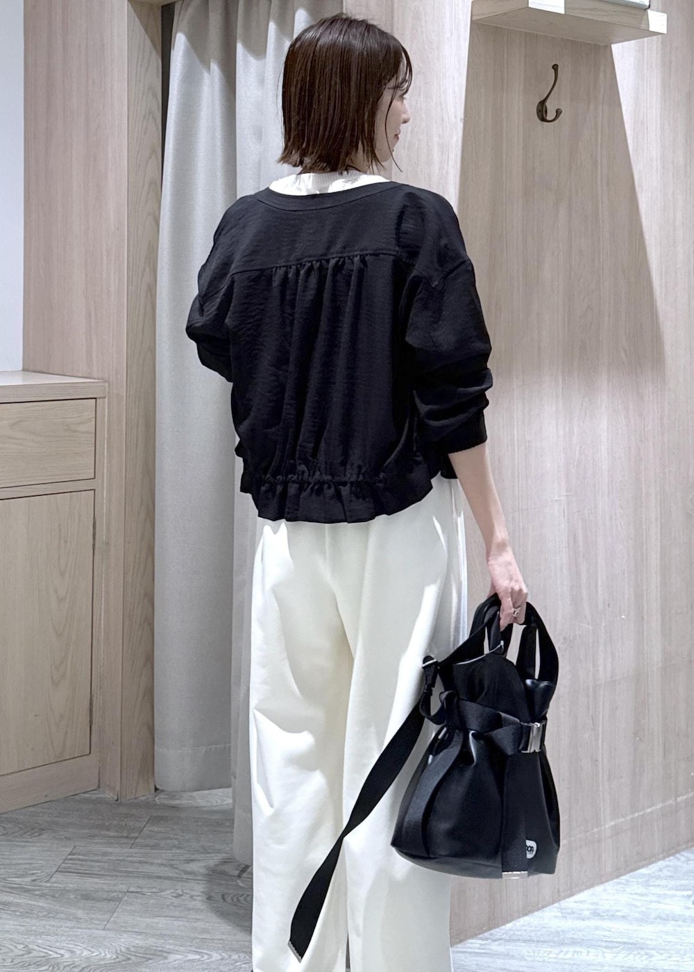 ブラック系のパンプス、ブラック系のトートバッグ、ブラック系のブルゾンを着用したレディースの春コーディネートの6枚目の写真