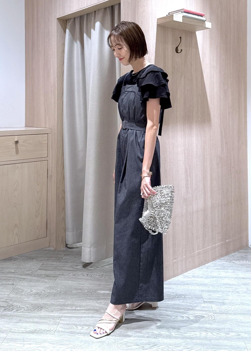 ホワイト系のサンダル、ブラック系のシャツ/ブラウス、シルバー系のハンドバッグを着用したレディースの夏コーディネートの3枚目の写真