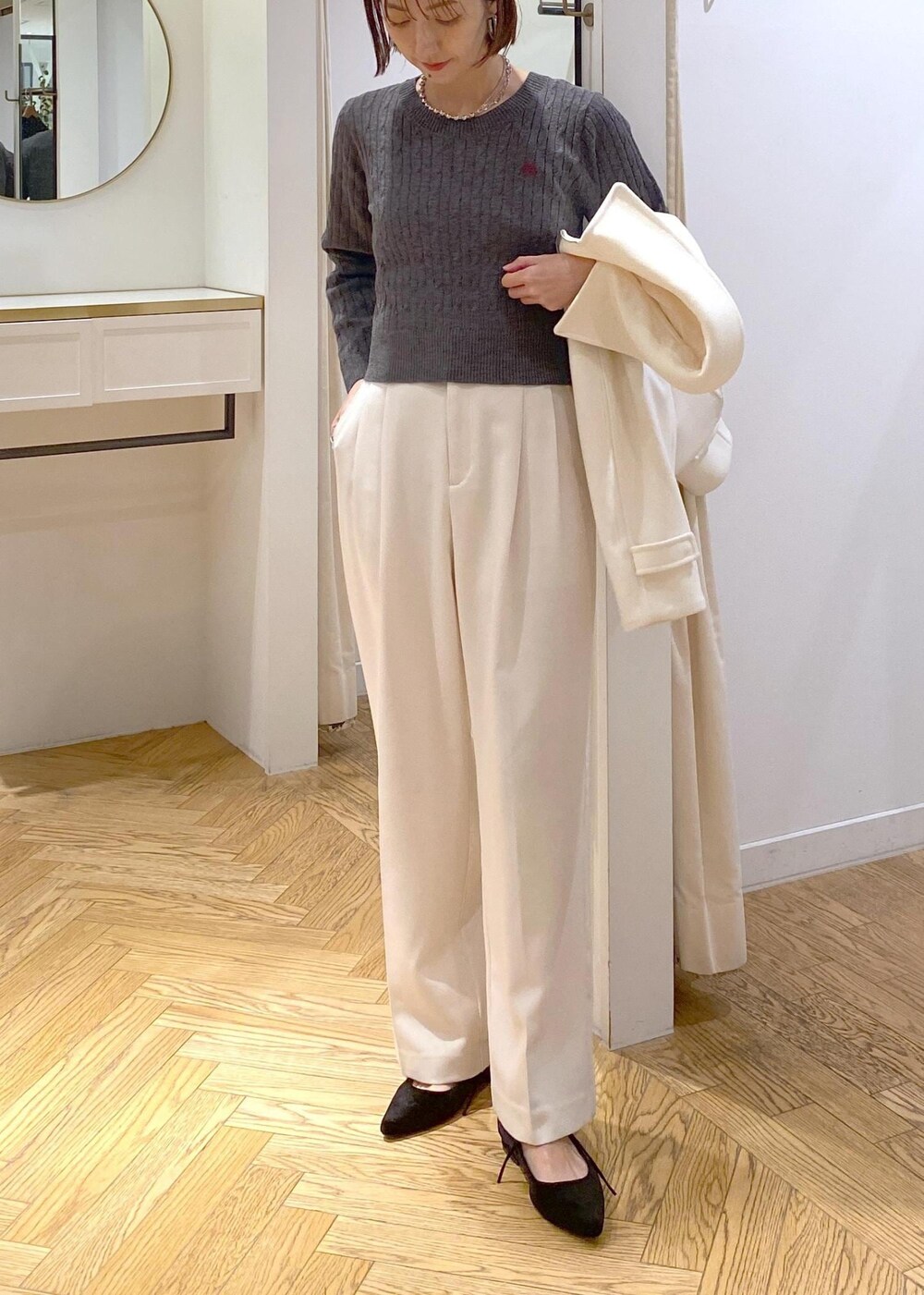 ブルー系のハンドバッグ、ホワイト系のブルゾン、ブラック系のパンプスを着用したレディースの冬コーディネートの8枚目の写真