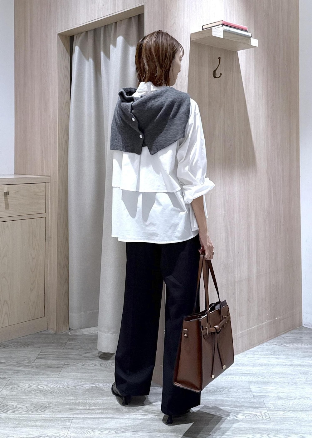 ブラウン系のトートバッグ、ホワイト系のシャツ/ブラウス、ブラック系のスラックスを着用したレディースの秋コーディネートの7枚目の写真