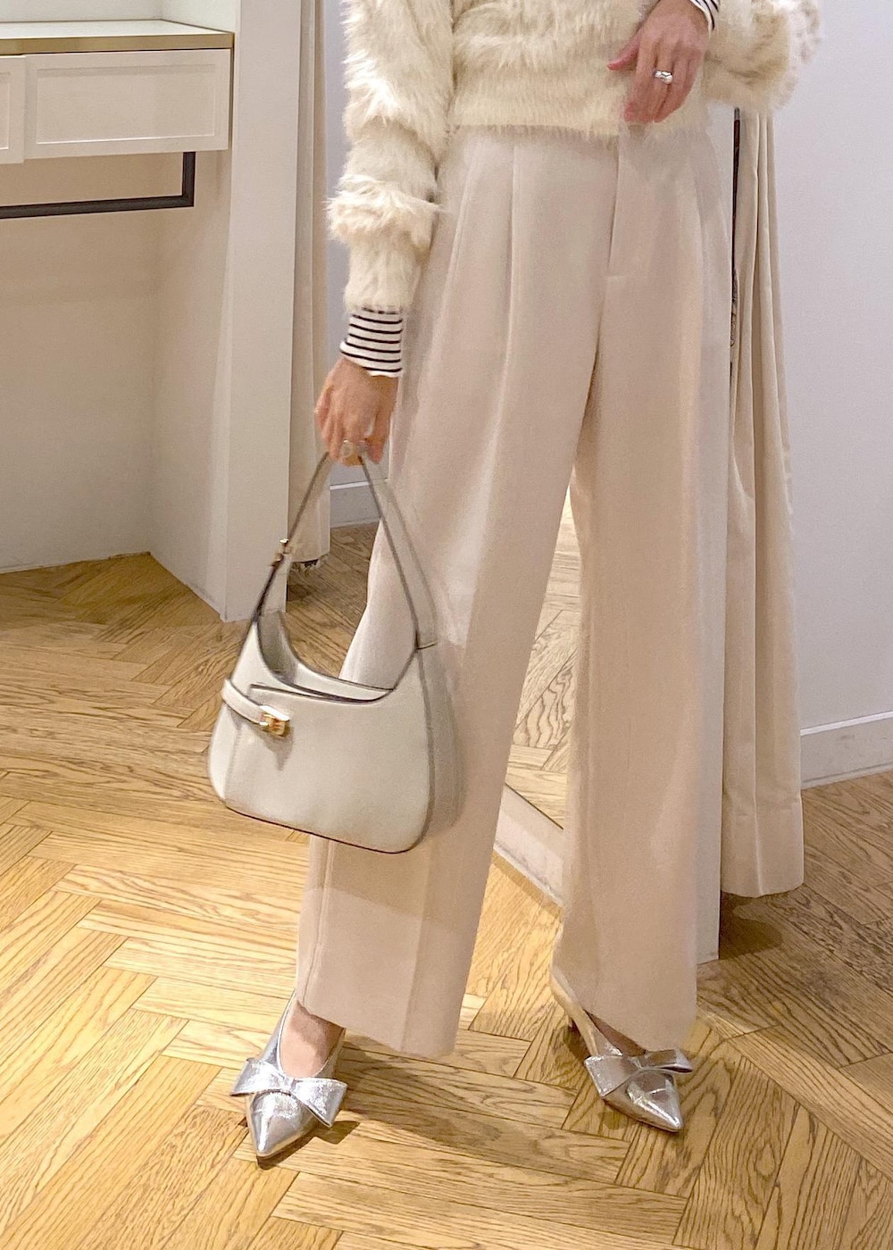 シルバー系のパンプス、ホワイト系のカーディガン/ボレロ、ホワイト系のTシャツ/カットソーを着用したレディースの冬コーディネートの6枚目の写真