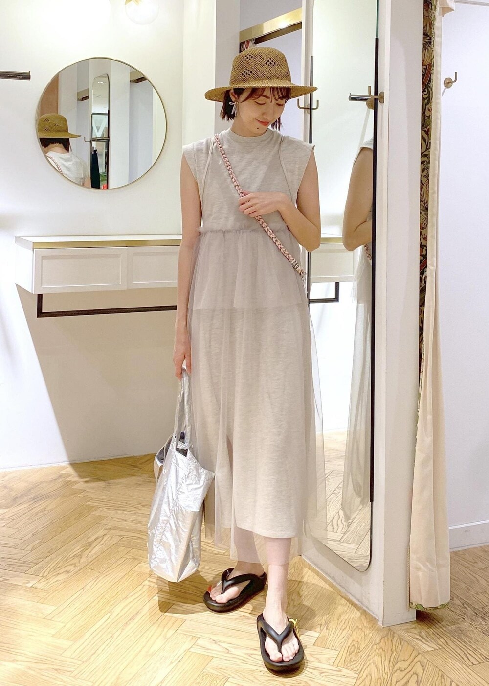 ブラック系のキャミソール、シルバー系のトートバッグ、ホワイト系のワンピースを着用したレディースの春コーディネートの6枚目の写真