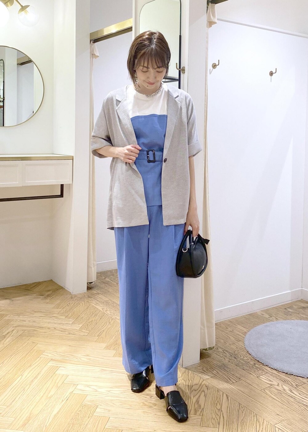 ブルー系のスラックス、ブラック系のショルダーバッグ、ブラック系のサンダルを着用したレディースの春コーディネートの3枚目の写真