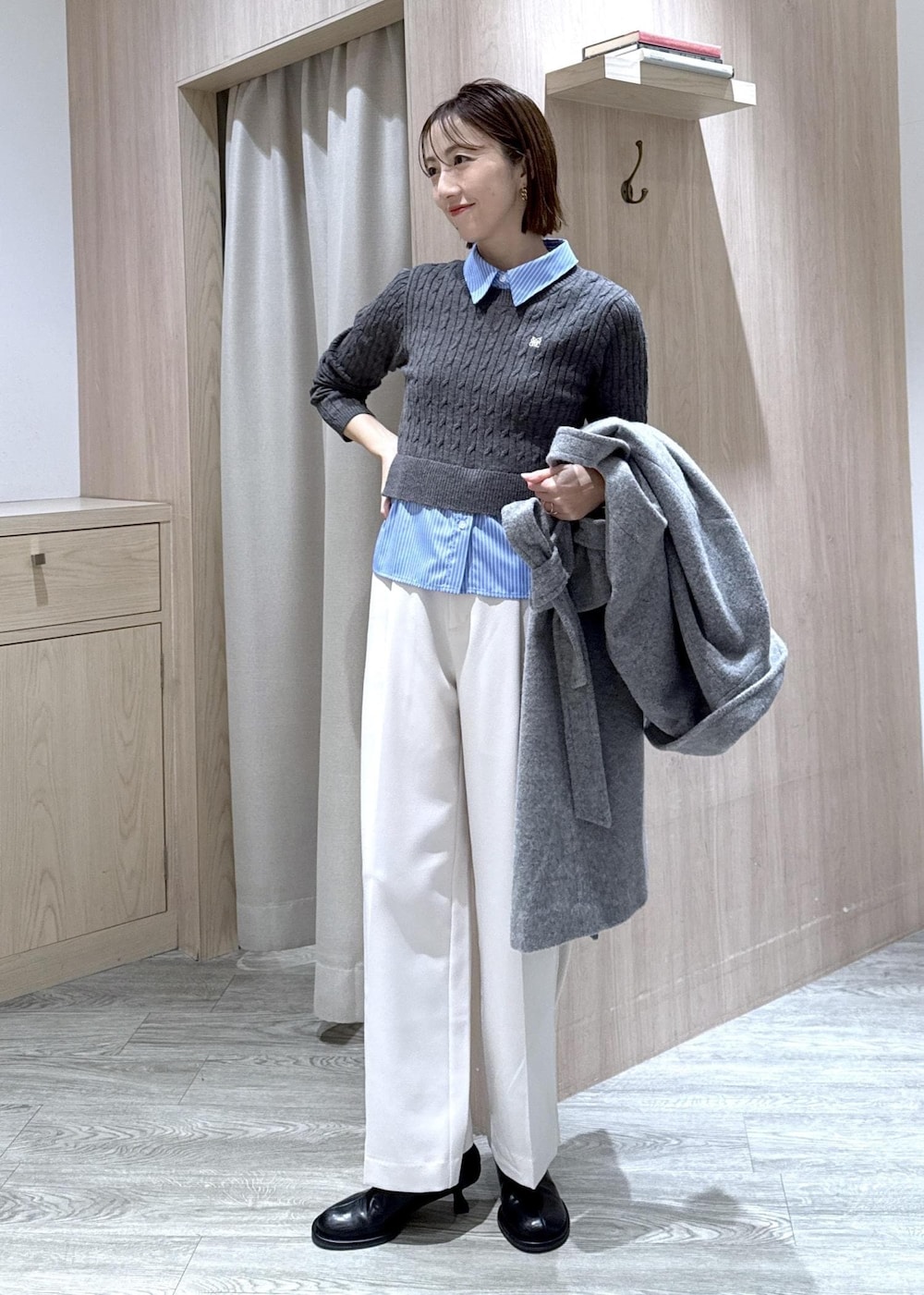 ブラック系のショルダーバッグ、グレー系のその他アウター、ホワイト系のスラックスを着用したレディースの冬コーディネートの7枚目の写真