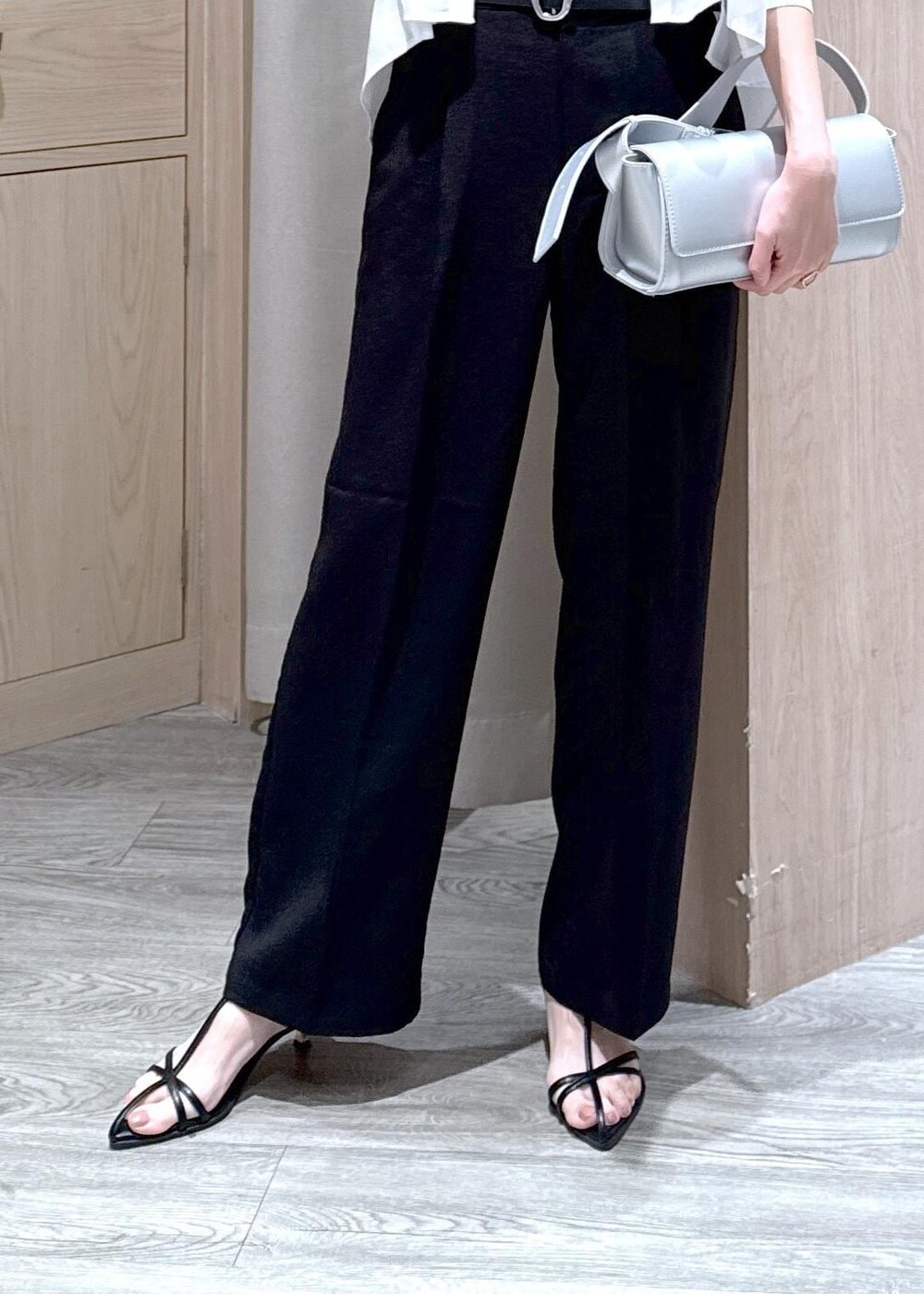 グレー系のタンクトップ、シルバー系のショルダーバッグ、ブラック系のサンダルを着用したレディースの春コーディネートの6枚目の写真