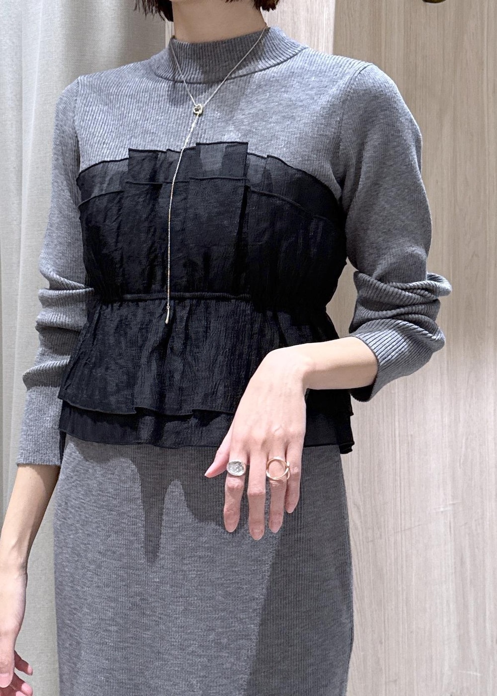 ブラック系のブーツ、ブラック系のダウンジャケット/コート、グレー系のスカートを着用したレディースの冬コーディネートの7枚目の写真