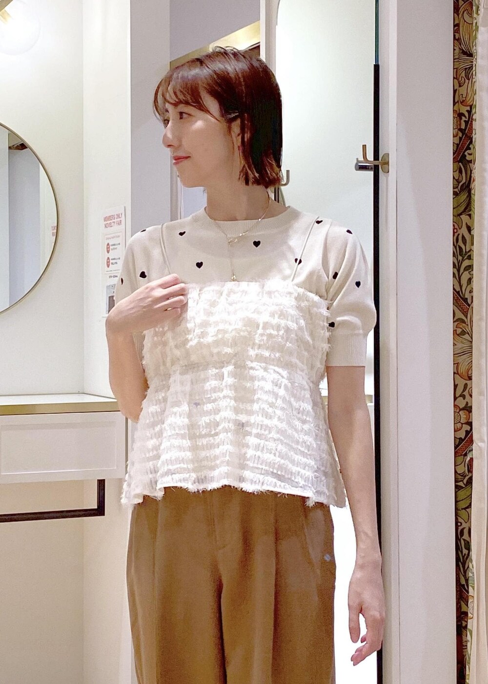 ブラック系のサンダル、ブラック系のハンドバッグ、ホワイト系のニット/セーターを着用したレディースの春コーディネートの4枚目の写真