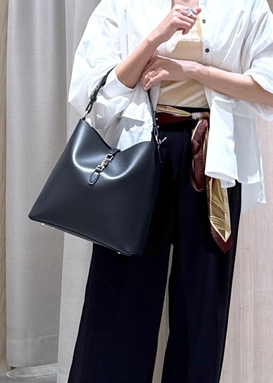 ブラック系のトートバッグ、イエロー系のパンプス、ホワイト系のシャツ/ブラウスを着用したレディースの秋コーディネートの7枚目の写真