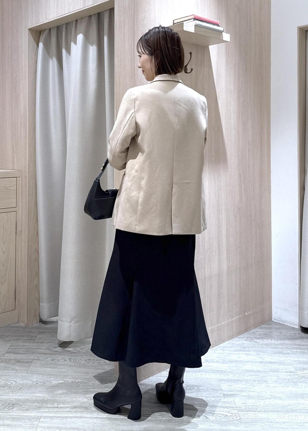 ブラック系のハンドバッグ、ブルー系のシャツ/ブラウス、ベージュ系のテーラードジャケットを着用したレディースの秋コーディネートの3枚目の写真