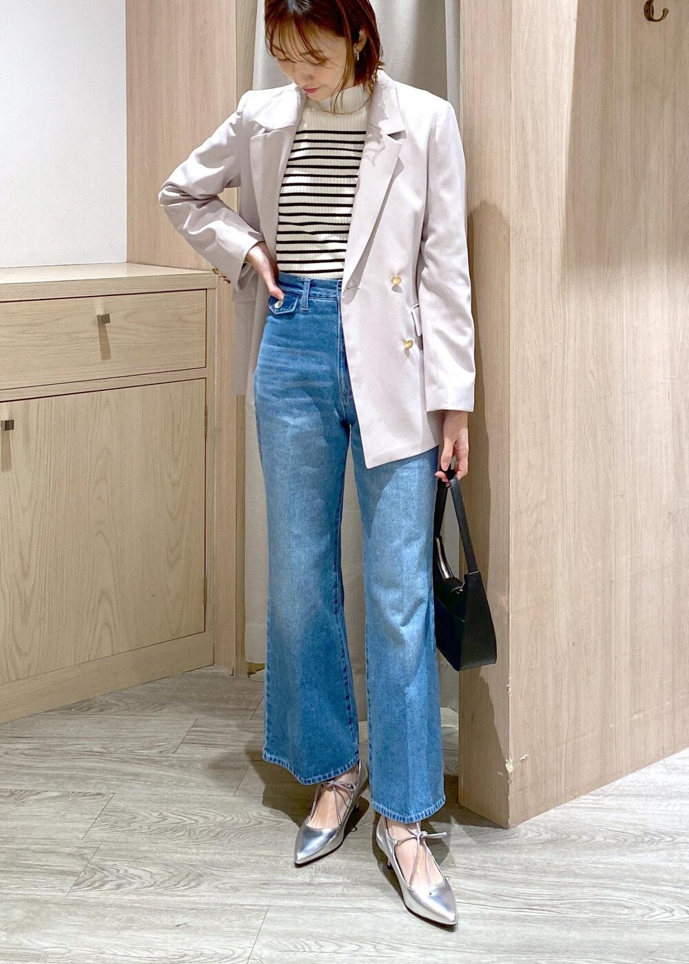 ブラック系のハンドバッグ、ホワイト系のニット/セーター、ベージュ系のテーラードジャケットを着用したレディースの冬コーディネートの4枚目の写真