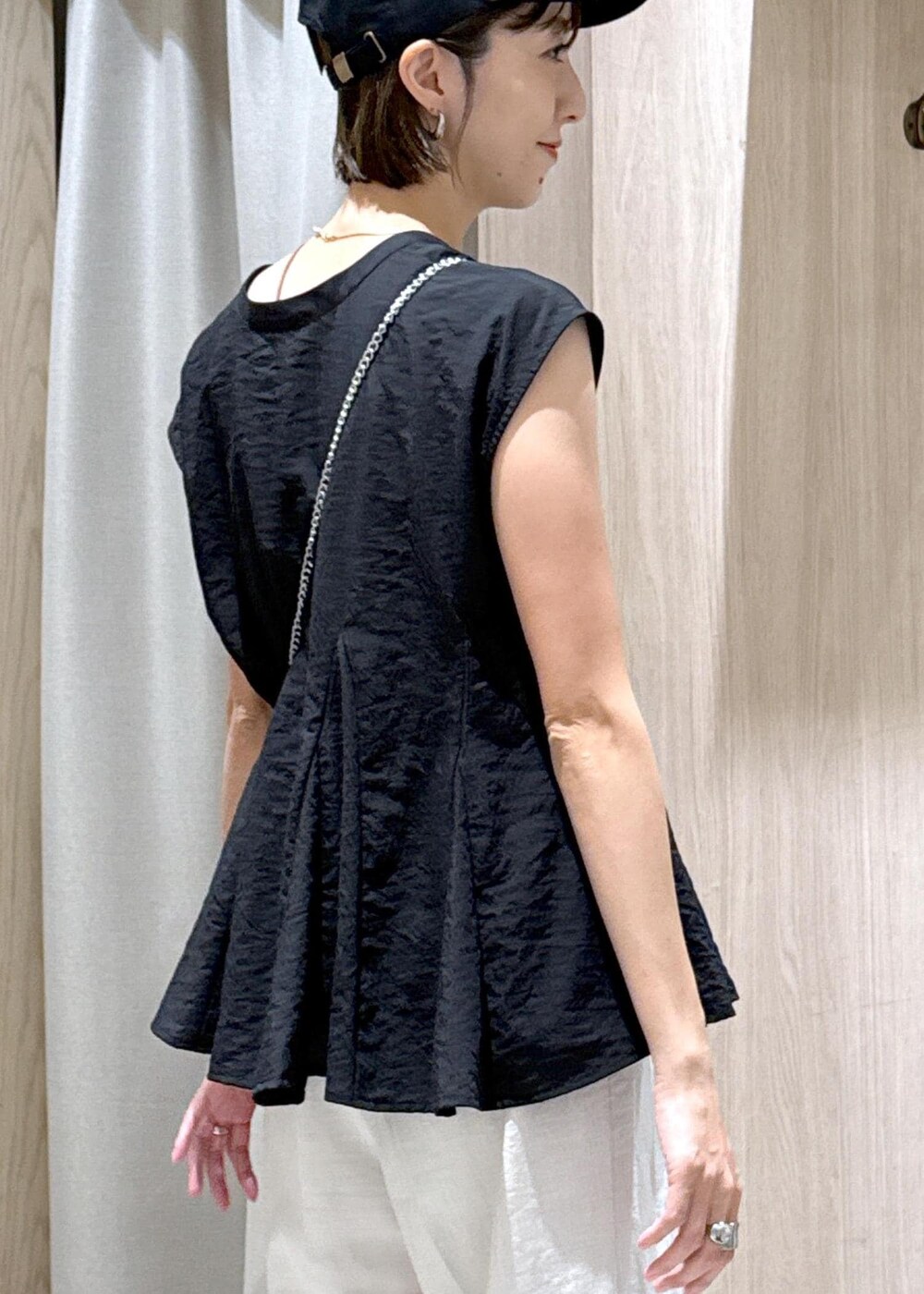 ブラック系のサンダル、ブラック系のシャツ/ブラウス、ホワイト系のスラックスを着用したレディースの夏コーディネートの9枚目の写真