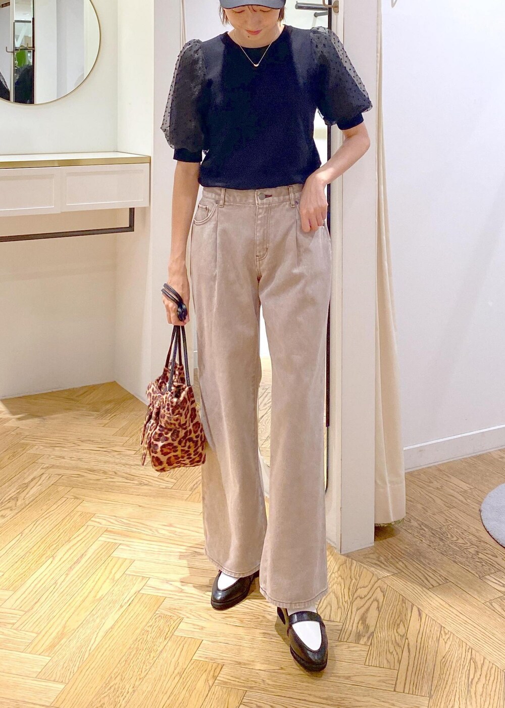 ブラック系のローファー、ブラック系のニット/セーター、ブラウン系のデニムパンツを着用したレディースの夏コーディネートの3枚目の写真