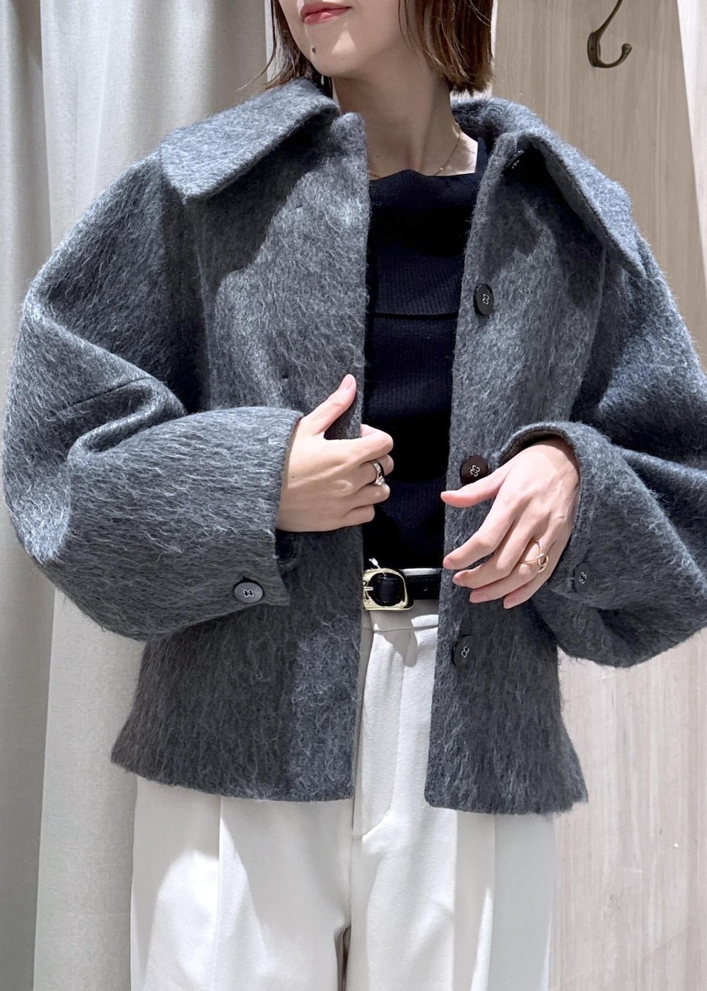 ブラック系のニット/セーター、グレー系のブルゾン、ブラック系のハンドバッグを着用したレディースの冬コーディネートの8枚目の写真