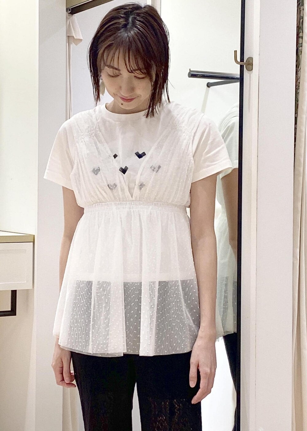 ブラック系のサンダル、ブラック系のハンドバッグ、ホワイト系のTシャツ/カットソーを着用したレディースの春コーディネートの4枚目の写真