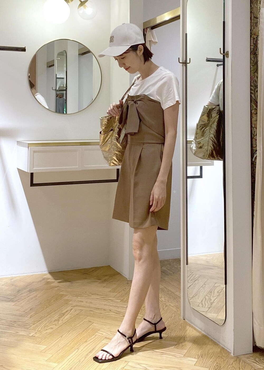 ブラック系のサンダル、ゴールド系のトートバッグ、ブラウン系のTシャツ/カットソーを着用したレディースの夏コーディネートの2枚目の写真