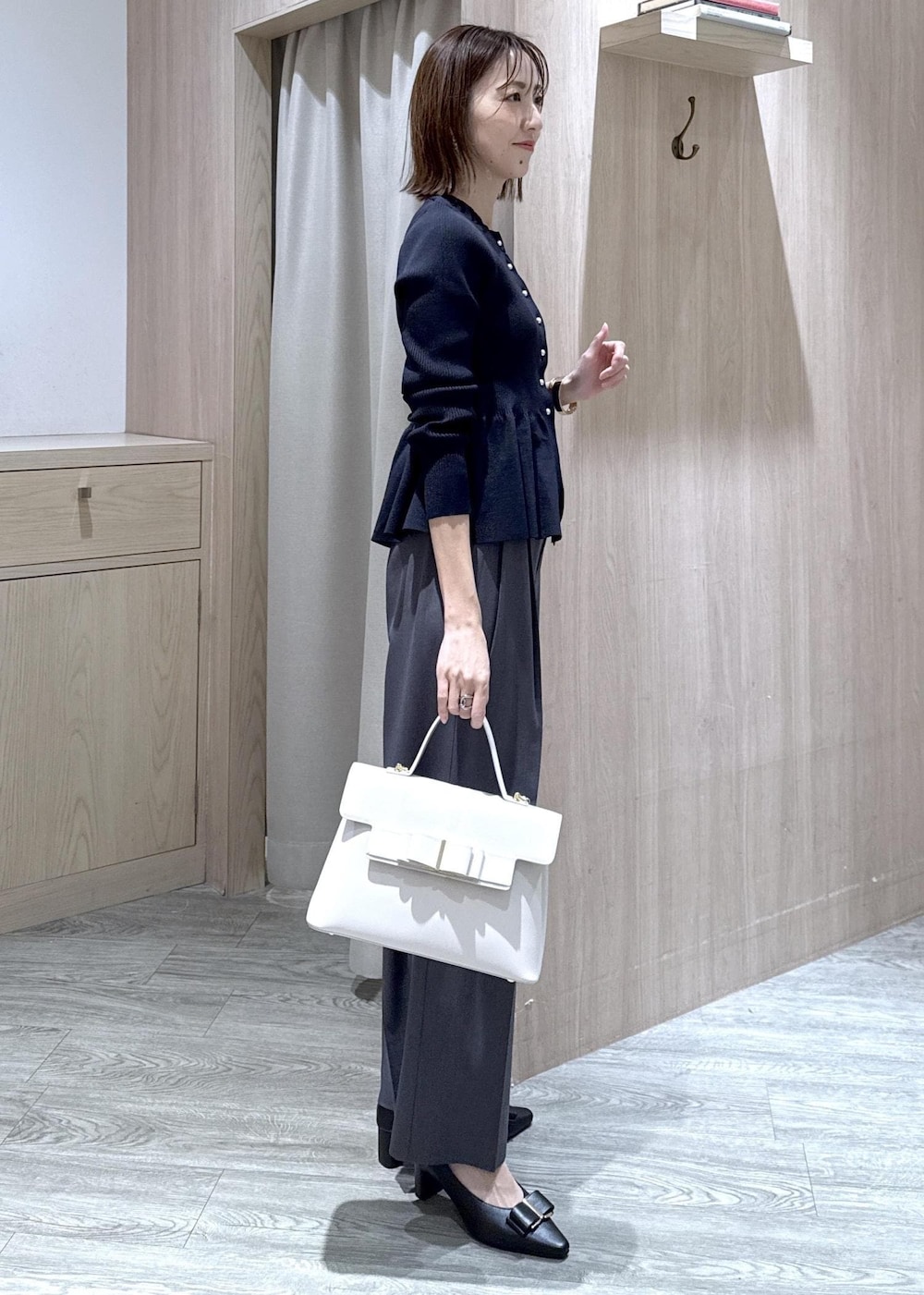 ブラック系のパンプス、グレー系のその他パンツ、ブルー系のカーディガン/ボレロを着用したレディースの冬コーディネートの4枚目の写真