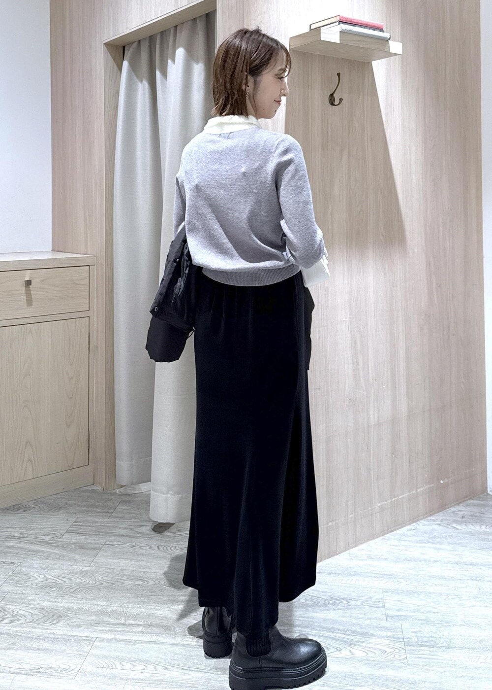 ブラック系のブーツ、ブラック系のスカート、ブラック系のダウンジャケット/コートを着用したレディースの冬コーディネートの6枚目の写真