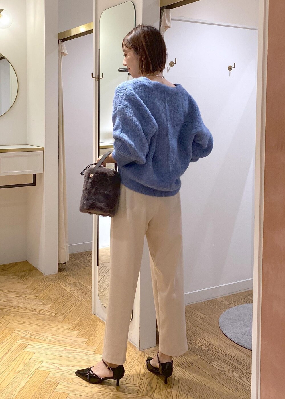 グレー系のショルダーバッグ、ブラック系のパンプス、ベージュ系のその他パンツを着用したレディースの冬コーディネートの2枚目の写真