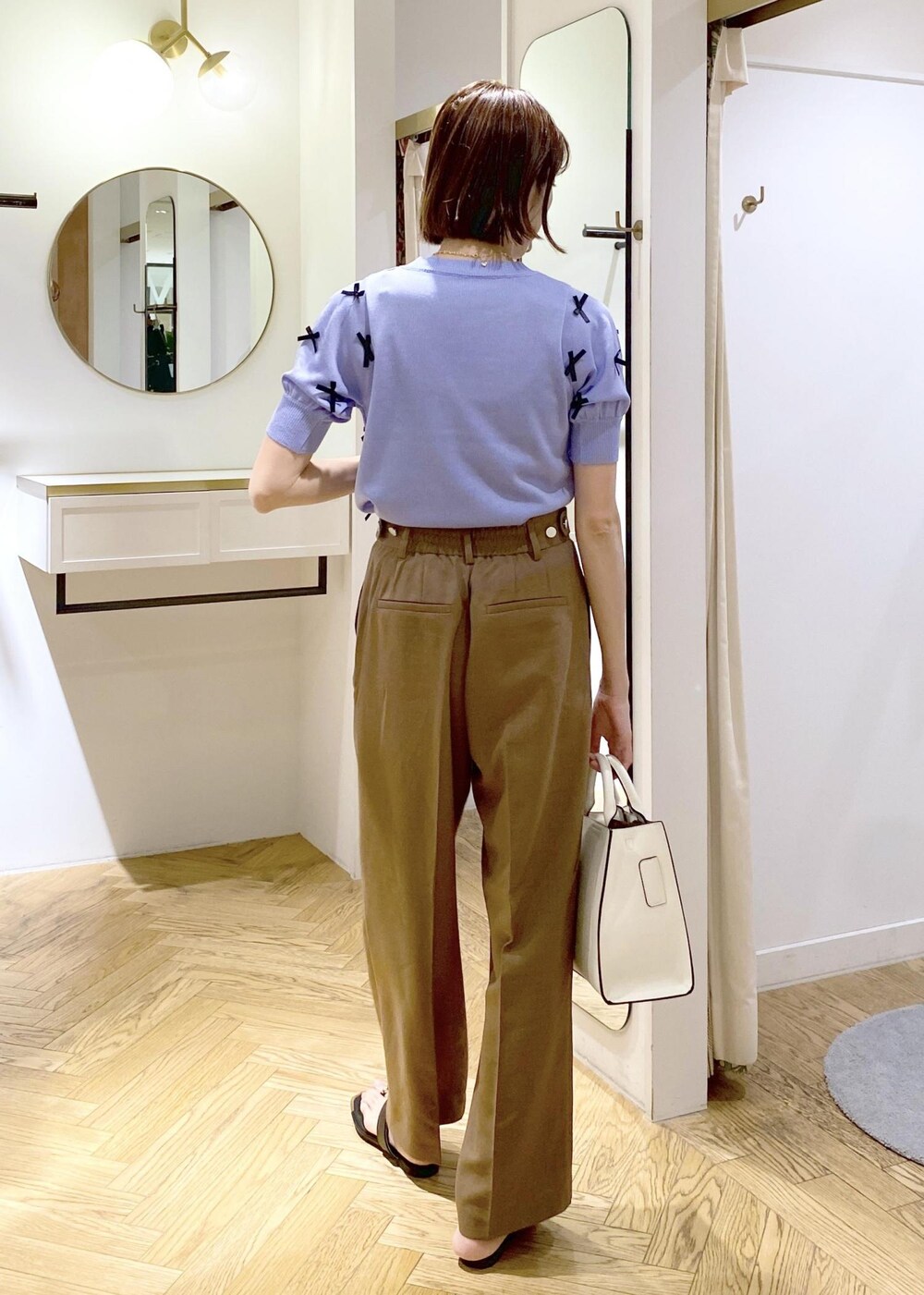 ブラック系のキャミソール、ブラック系のサンダル、ホワイト系のハンドバッグを着用したレディースの春コーディネートの3枚目の写真