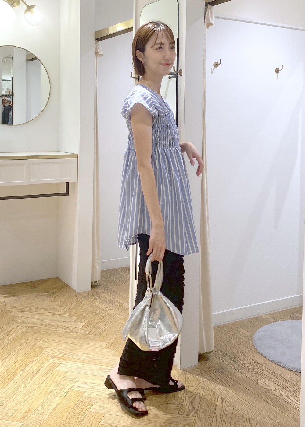 ブラック系のサンダル、ブラック系のスカート、ブラック系のキャミソールを着用したレディースの夏コーディネートの2枚目の写真