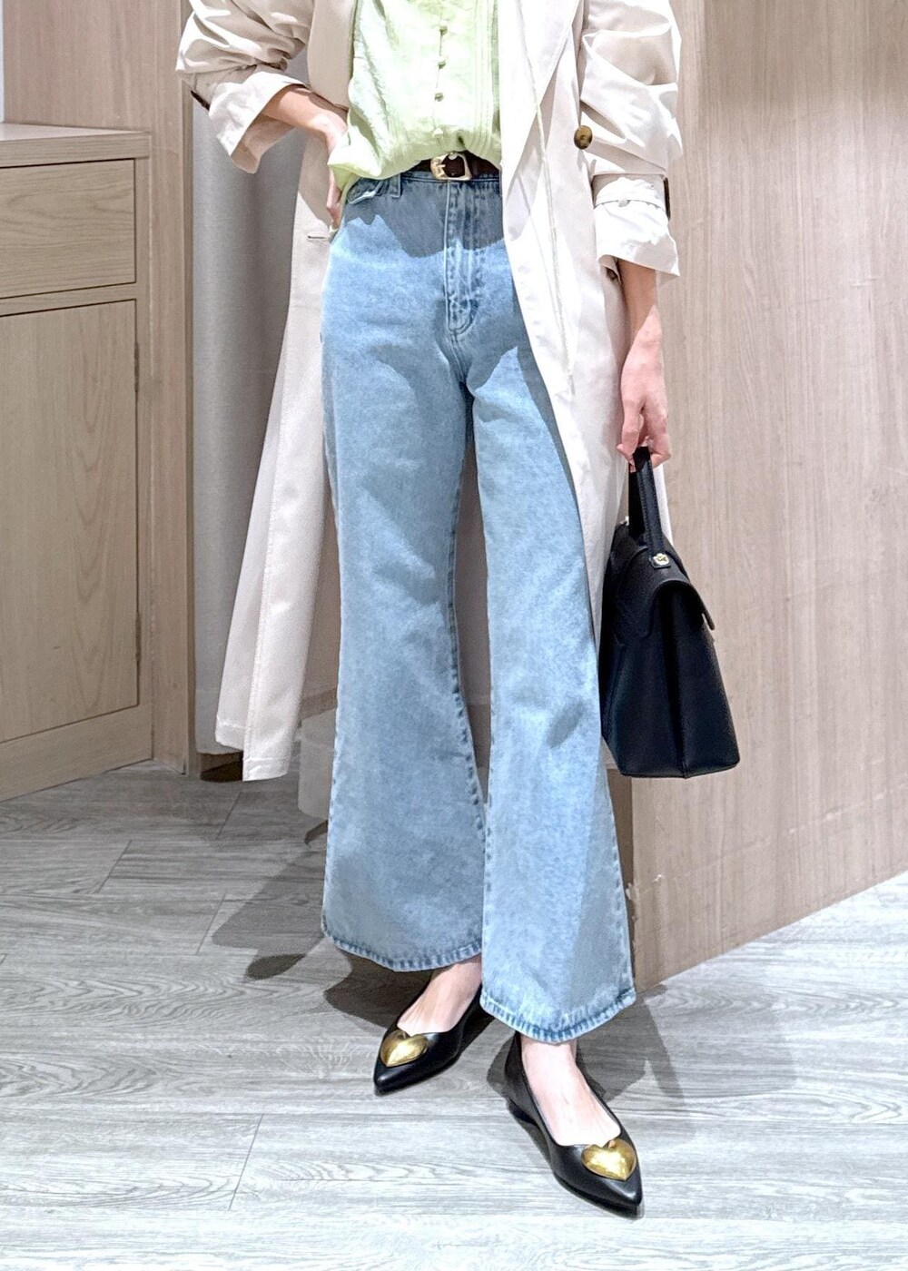 ブラック系のハンドバッグ、ブラック系のバレエシューズ、ホワイト系のトレンチコートを着用したレディースの春コーディネートの7枚目の写真