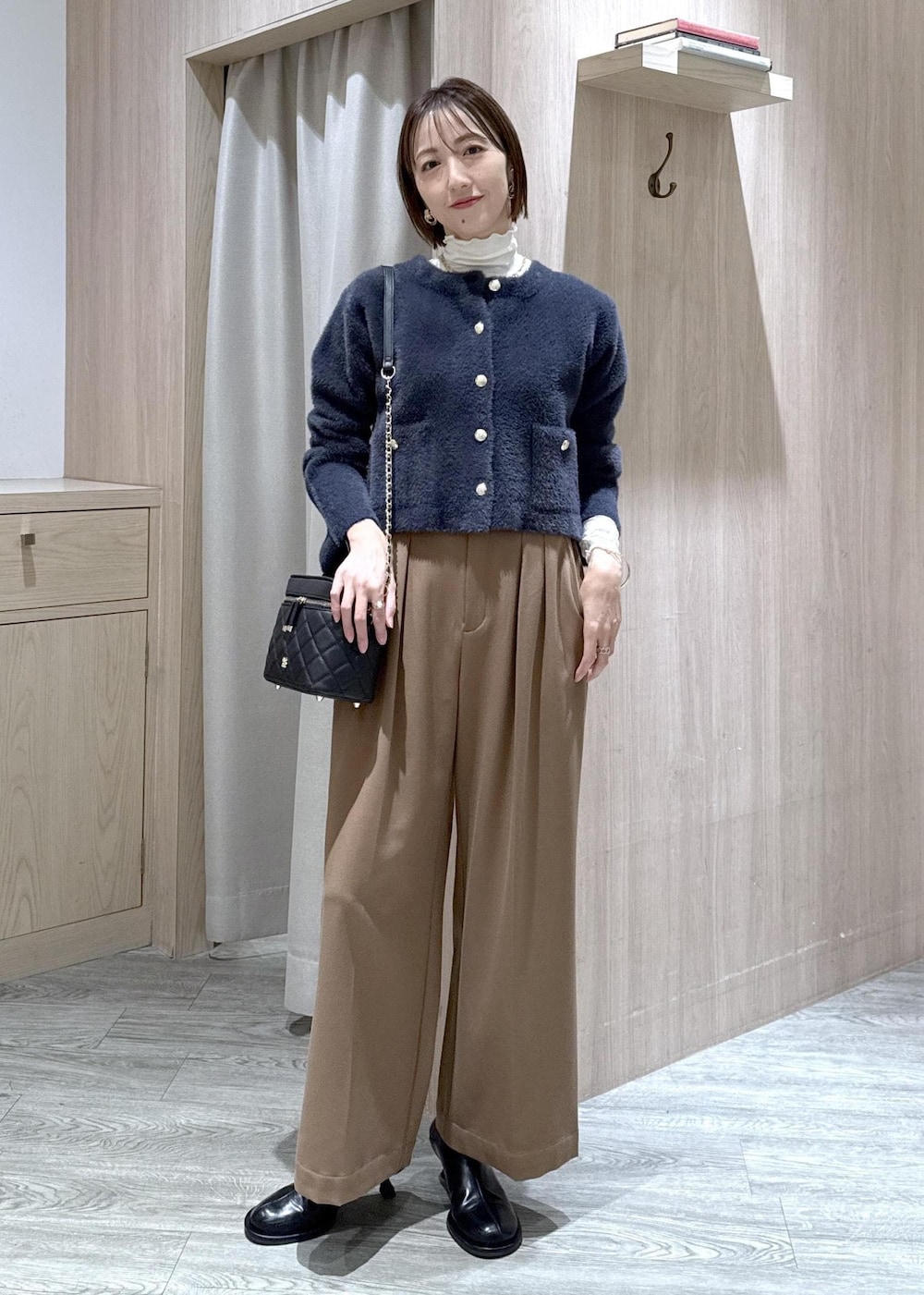 ブルー系のカーディガン/ボレロ、ホワイト系のTシャツ/カットソー、ブラック系のブーツを着用したレディースの冬コーディネートの2枚目の写真