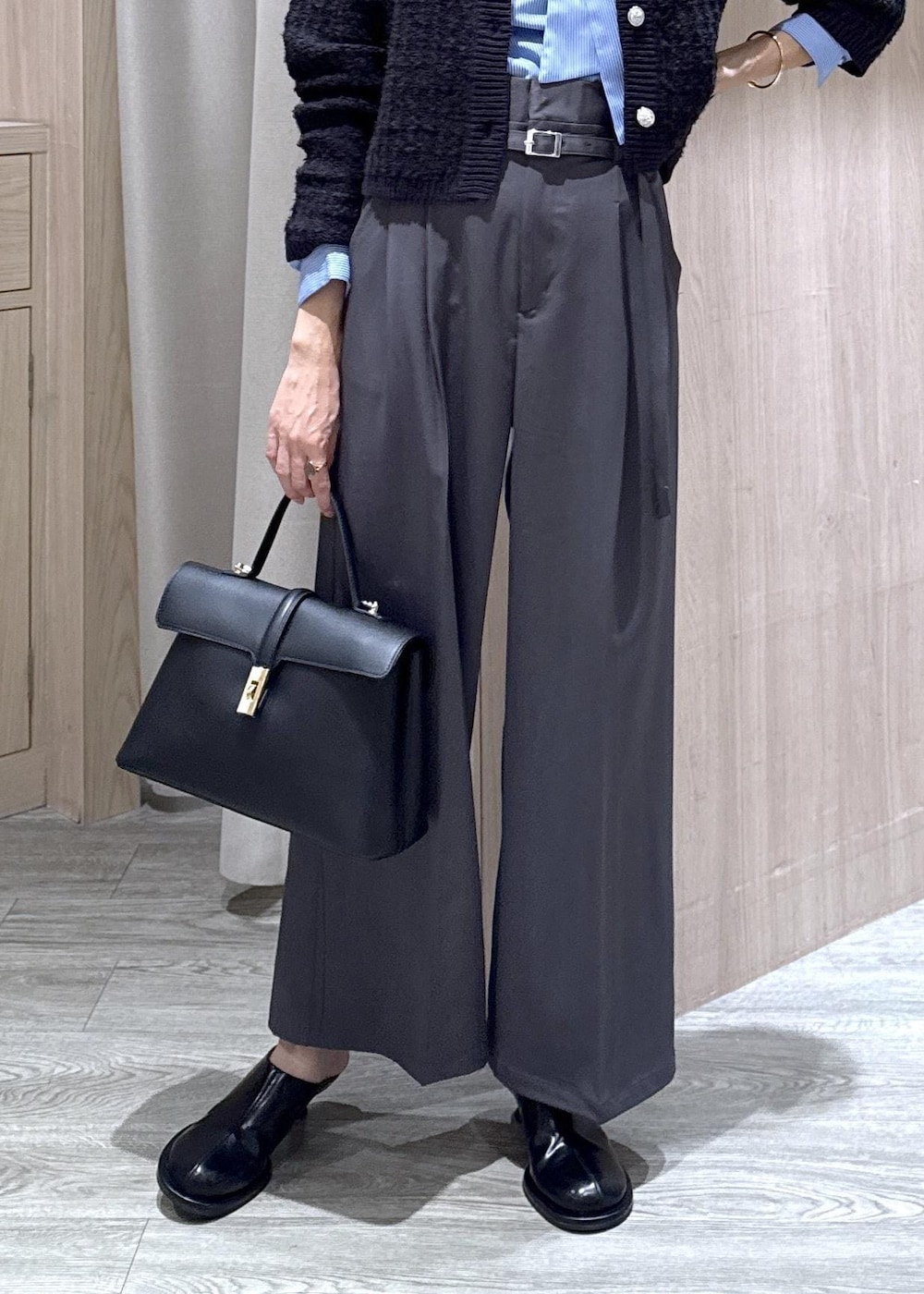 ブラック系のハンドバッグ、ブルー系のカーディガン/ボレロ、グレー系のその他パンツを着用したレディースの秋コーディネートの4枚目の写真