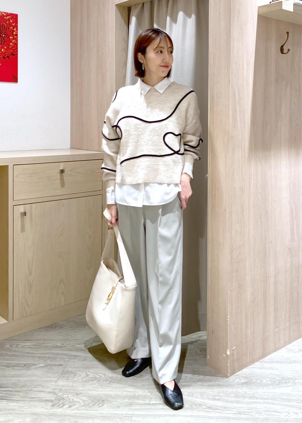 ホワイト系のトートバッグ、ホワイト系のニット/セーター、ホワイト系のシャツ/ブラウスを着用したレディースの冬コーディネートの4枚目の写真