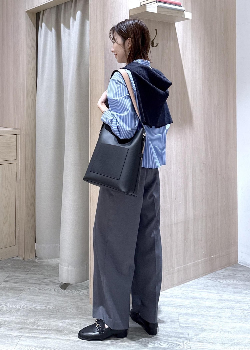 ブラック系のトートバッグ、ブルー系のカーディガン/ボレロ、グレー系のその他パンツを着用したレディースの冬コーディネートの2枚目の写真