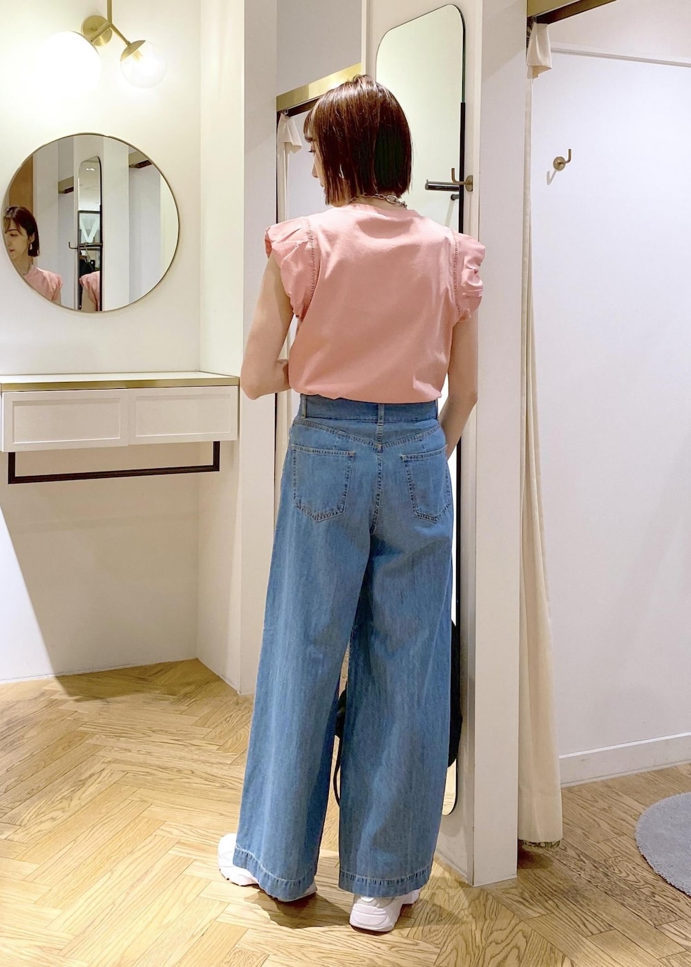 グレー系のスニーカー、ブラック系のバックパック/リュック、ピンク系のTシャツ/カットソーを着用したレディースの春コーディネートの2枚目の写真