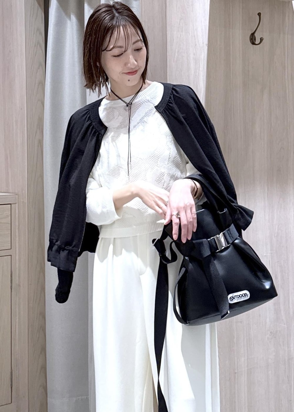 ブラック系のパンプス、ブラック系のトートバッグ、ブラック系のブルゾンを着用したレディースの春コーディネートの3枚目の写真