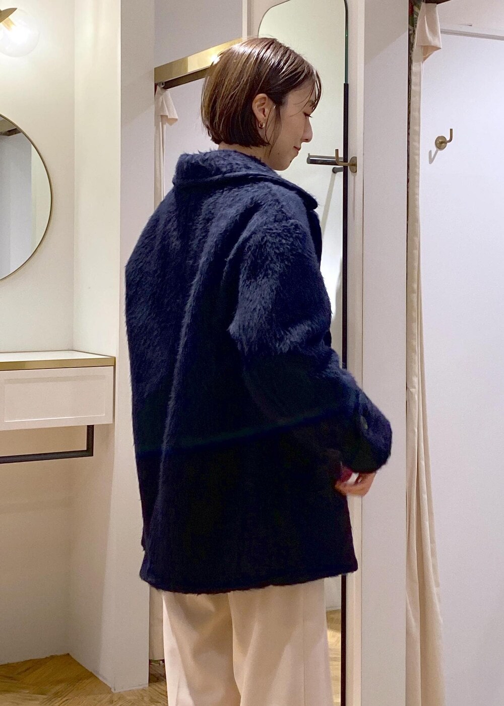 ホワイト系のブーツ、グレー系のカーディガン/ボレロ、レッド系のニット/セーターを着用したレディースの冬コーディネートの6枚目の写真