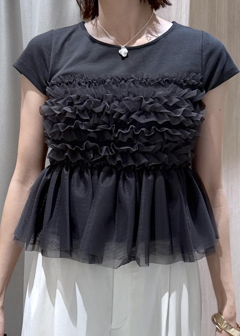ブラック系のショルダーバッグ、ブラック系のパンプス、グレー系のTシャツ/カットソーを着用したレディースの夏コーディネートの8枚目の写真