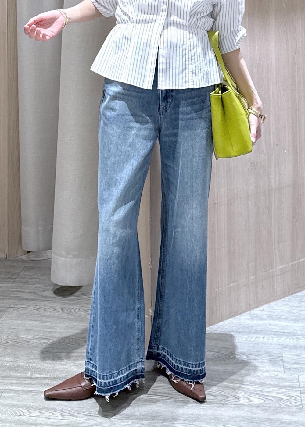 ブルー系のデニムパンツ、グリーン系のトートバッグ、ホワイト系のシャツ/ブラウスを着用したレディースの春コーディネートの10枚目の写真