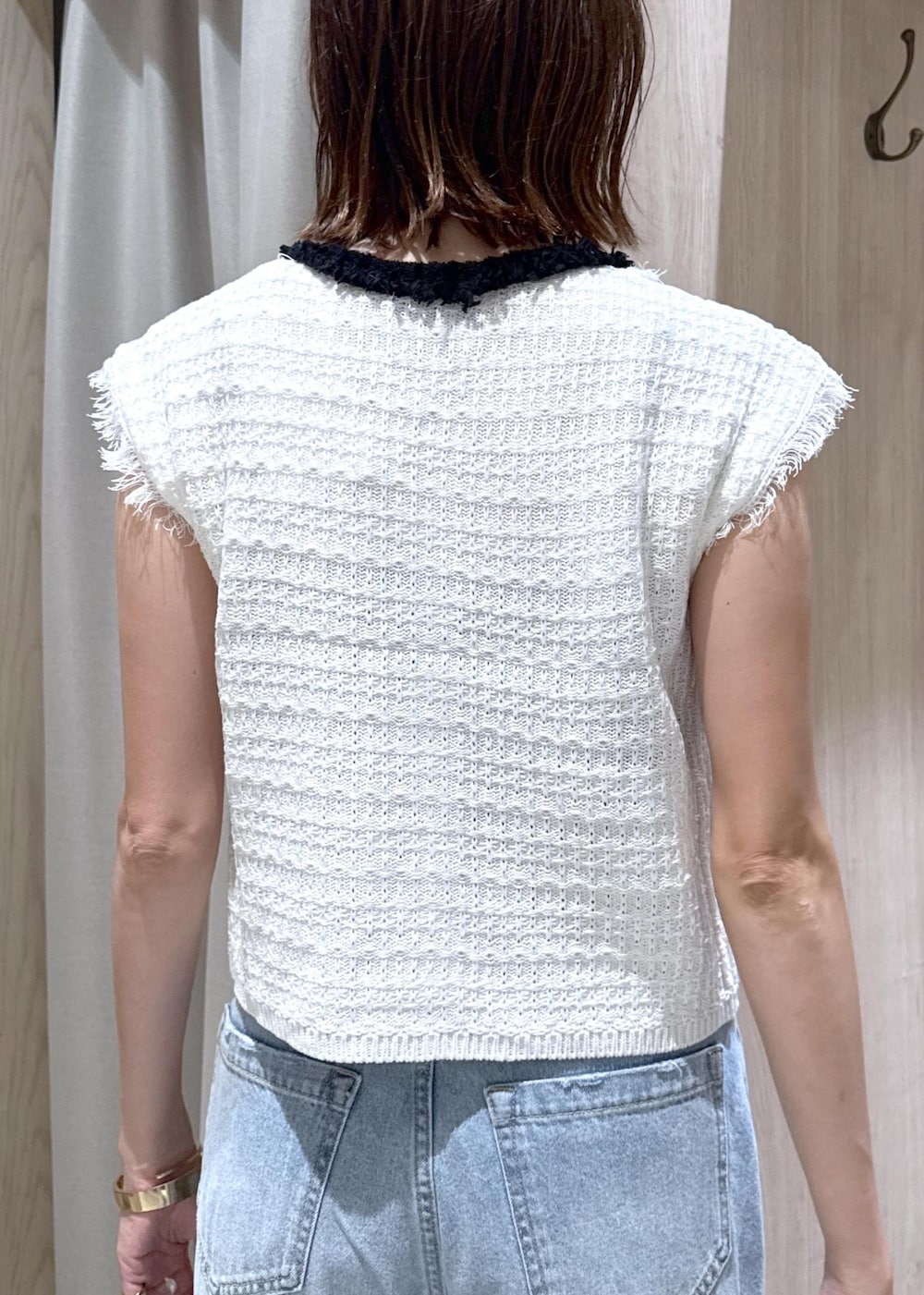 ブラック系のパンプス、ブルー系のデニムパンツ、ホワイト系のベストを着用したレディースの夏コーディネートの8枚目の写真