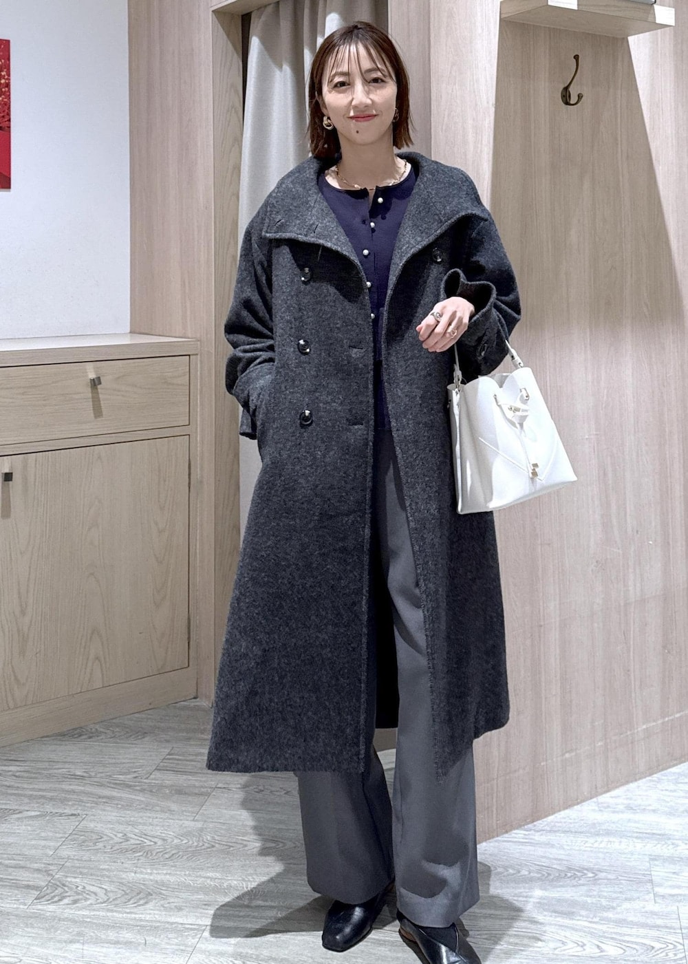 ホワイト系のショルダーバッグ、ブルー系のカーディガン/ボレロ、グレー系のその他アウターを着用したレディースの冬コーディネートの2枚目の写真