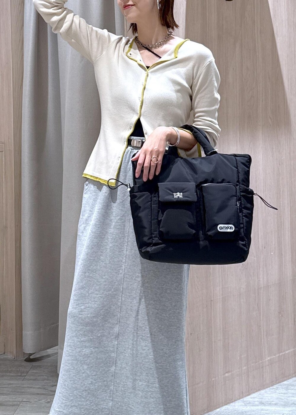 ブラック系のキャミソール、ブラック系のトートバッグ、ベージュ系のカーディガン/ボレロを着用したレディースの秋コーディネートの6枚目の写真