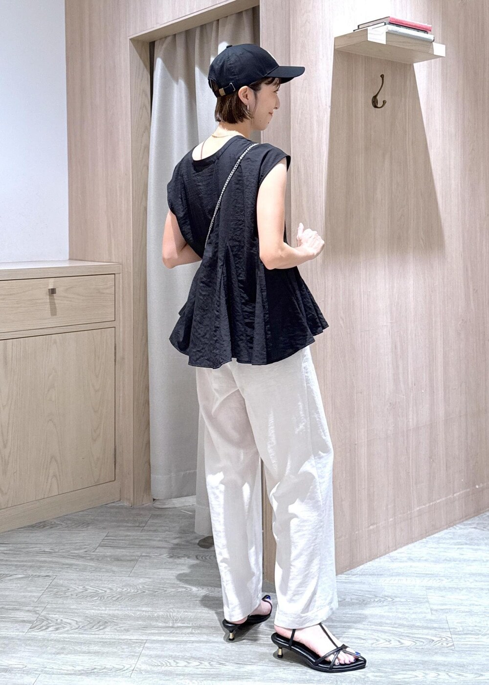 ブラック系のサンダル、ブラック系のシャツ/ブラウス、ホワイト系のスラックスを着用したレディースの夏コーディネートの5枚目の写真