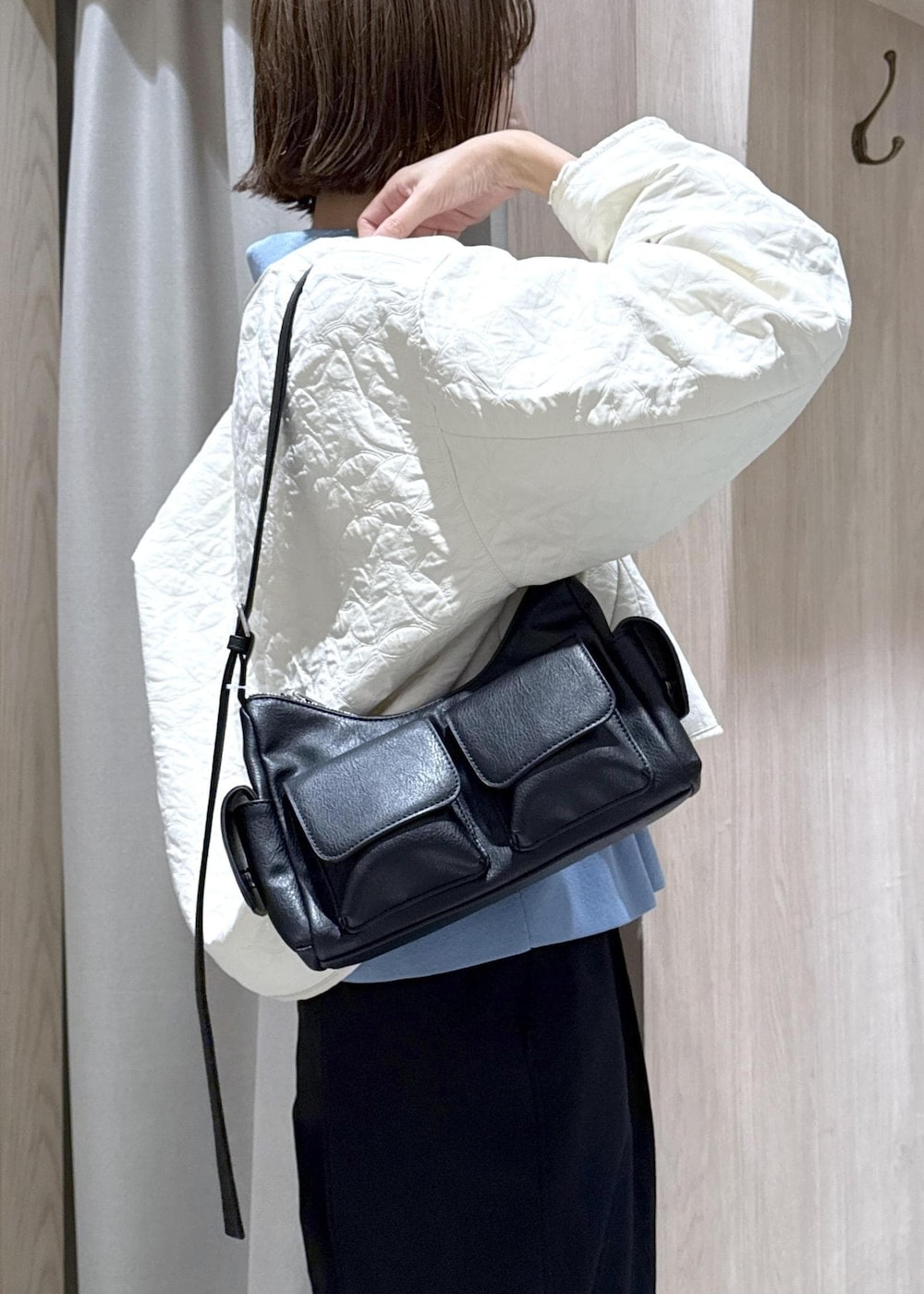 ブラック系のスラックス、ブラック系のショルダーバッグ、ブルー系のカーディガン/ボレロを着用したレディースの秋コーディネートの9枚目の写真