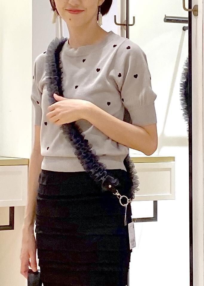 ブラック系のハンドバッグ、ブラック系のサンダル、グレー系のニット/セーターを着用したレディースの夏コーディネートの4枚目の写真