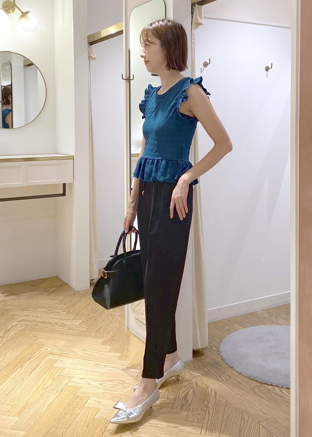 シルバー系のパンプス、ブラック系のスラックス、ブラック系のキャミソールを着用したレディースの夏コーディネートの3枚目の写真