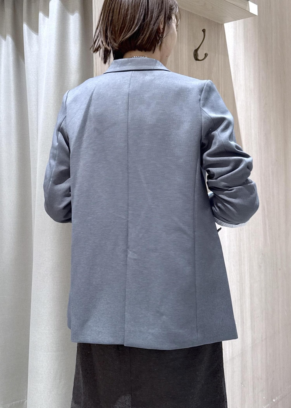 グレー系のテーラードジャケット、ブルー系のカーディガン/ボレロ、ブラウン系のスカートを着用したレディースの秋コーディネートの8枚目の写真