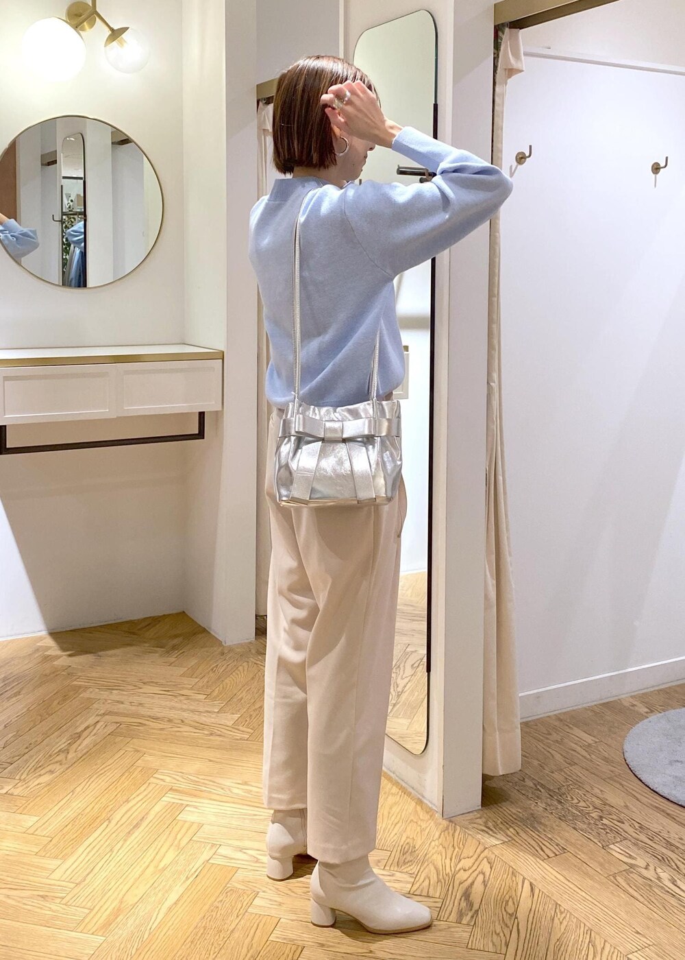 ホワイト系のブーツ、ブルー系のニット/セーター、ベージュ系のその他パンツを着用したレディースの冬コーディネートの3枚目の写真