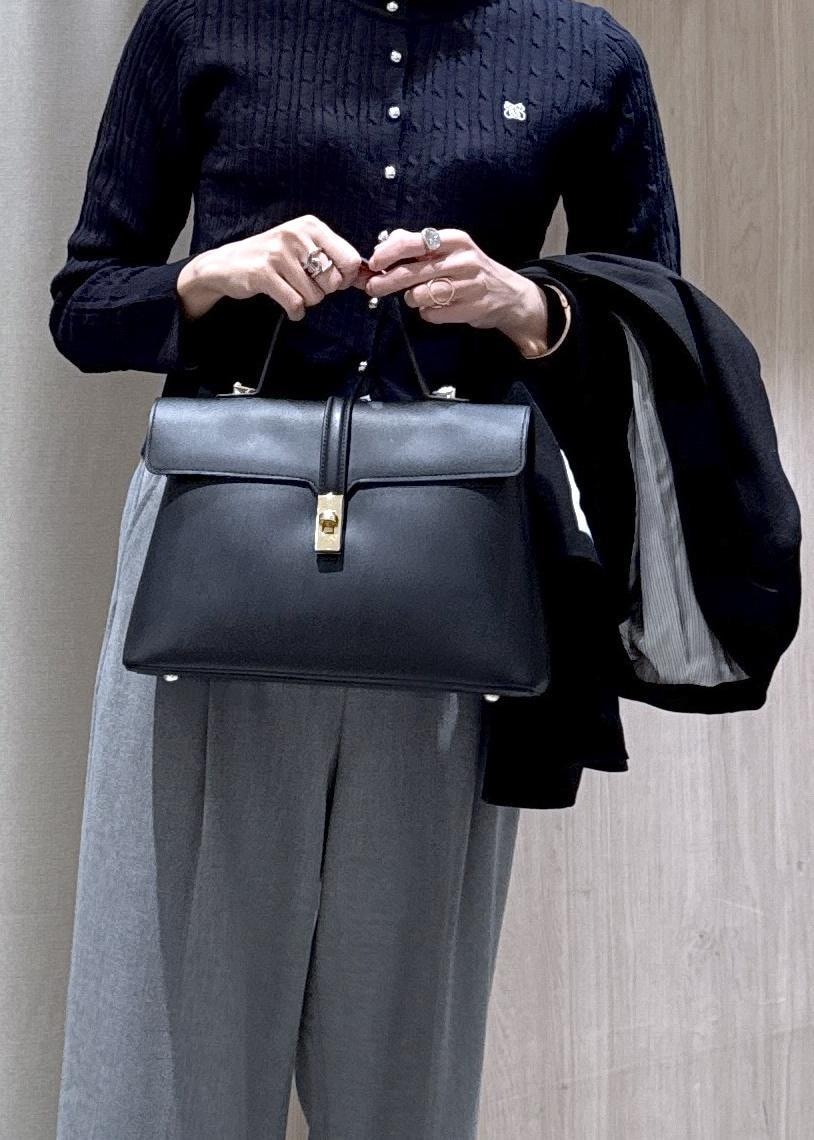 ブラック系のハンドバッグ、ブラック系のテーラードジャケット、グレー系のその他パンツを着用したレディースの冬コーディネートの4枚目の写真