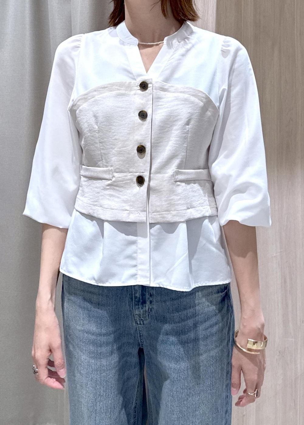 イエロー系のショルダーバッグ、ピンク系のナイロンジャケット、ブルー系のデニムパンツを着用したレディースの春コーディネートの9枚目の写真